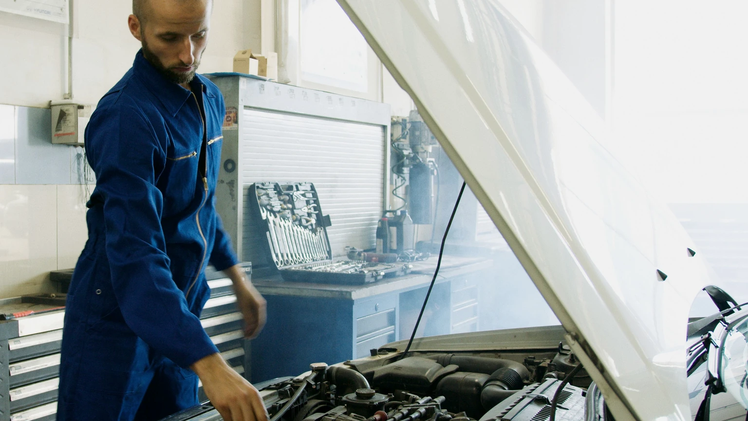 Technician inspecting a vehicle engine during routine maintenance