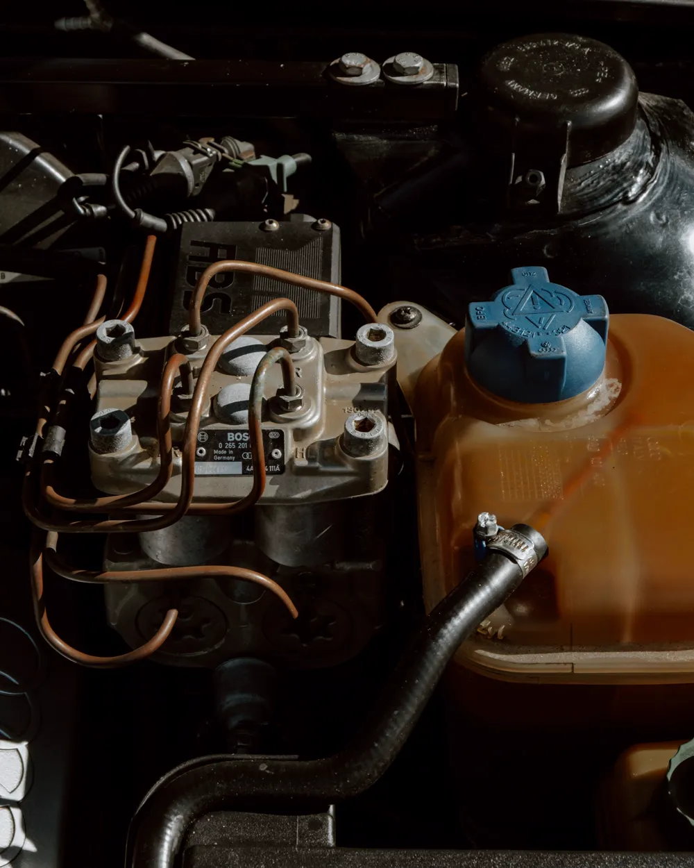 Engine bay with a translucent coolant reservoir and blue cap