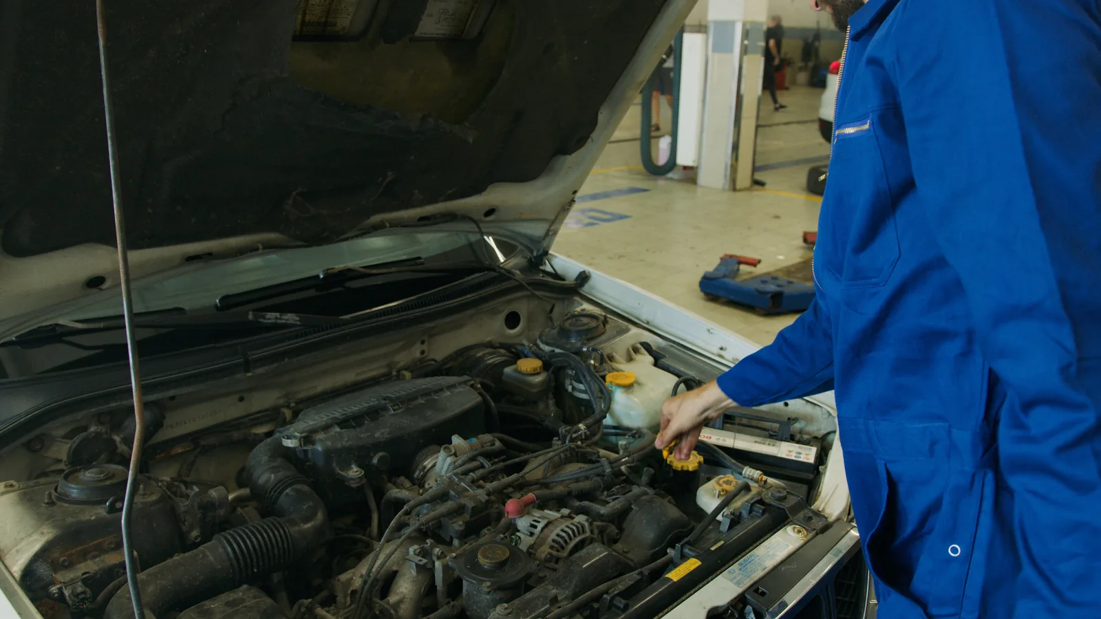 Mechanic inspecting an engine bay in a workshop