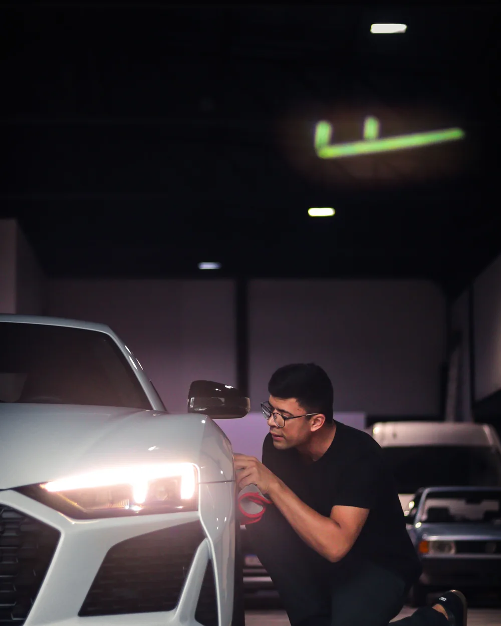Technician visually inspecting a car headlight assembly