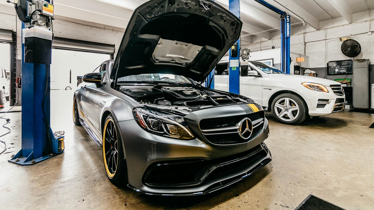 Two vehicles with open hoods in the Big Mission Automotive workshop